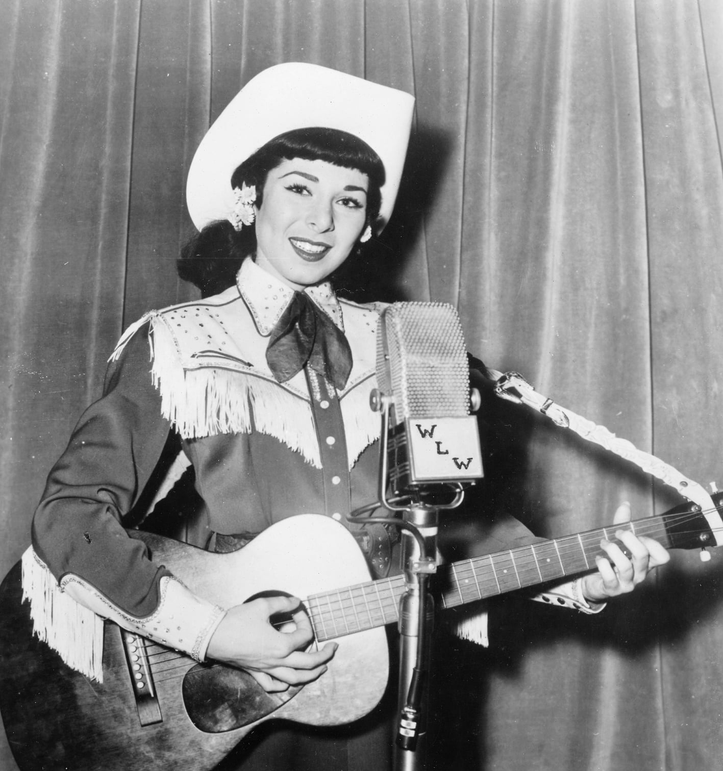 Mimi Roman performing in western stage wear in front of a WLW radio microphone, 1950s.